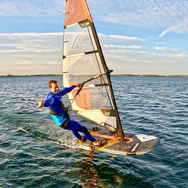 Vindsurfare foilar med Patrik GT-3 Foil-segel, visar tummen upp