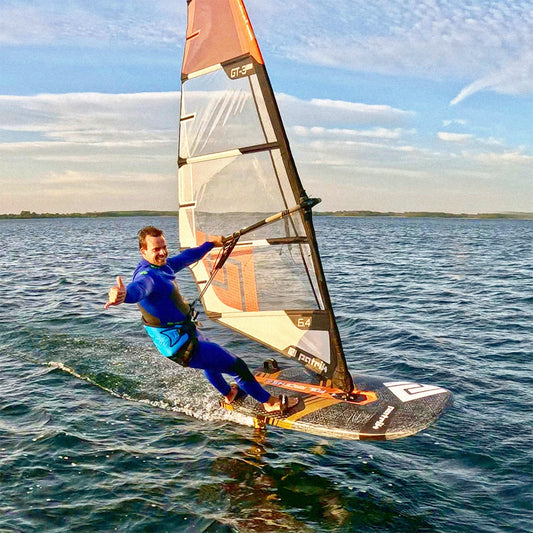 Vindsurfare foilar med Patrik GT-3 Foil-segel, visar tummen upp