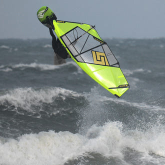Vindsurfare hoppar upp och ner med gult Patrik 4-Wave LTD-segel